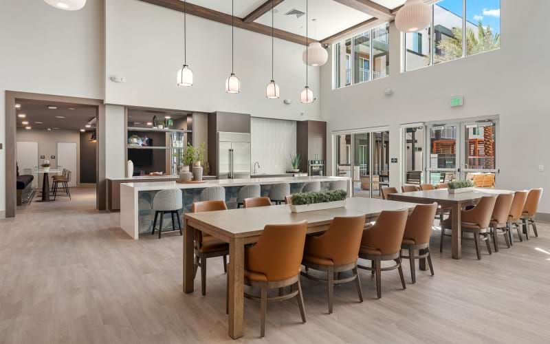 a spacious resident lounge with a kitchen and natural lighting