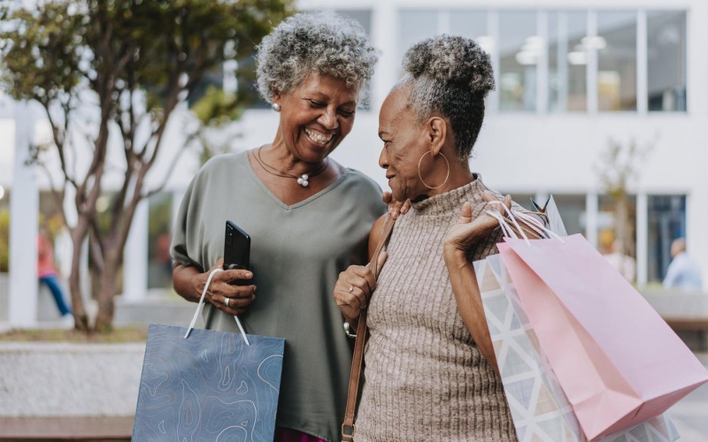 A beautiful community at the heart of all your passions a couple of women smiling and holding shopping bags