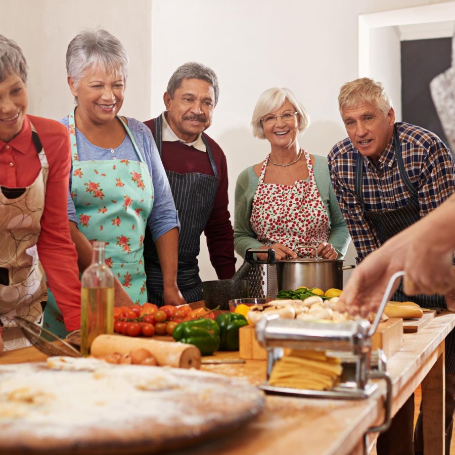 Close to the center of everything a group of people standing around a table with food on it