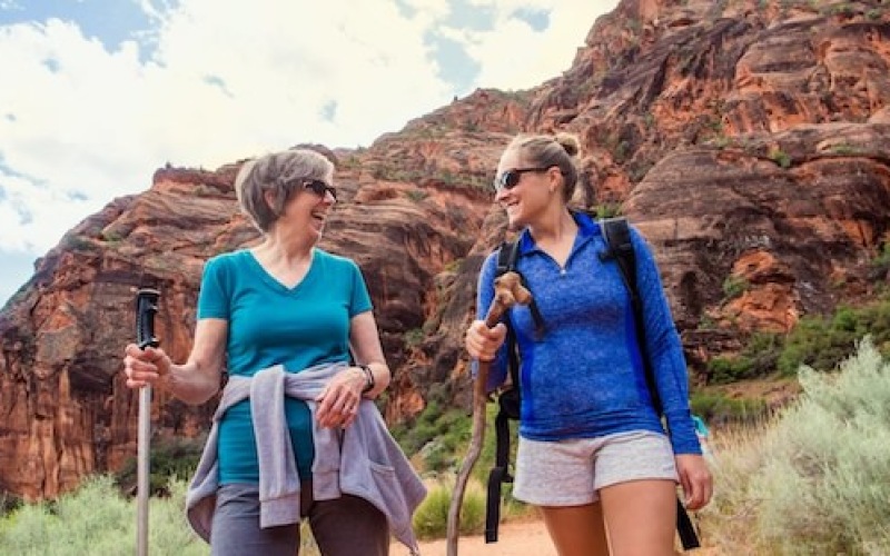 Senior women walking on a trail near Album Union Village, with a mountain in the background.