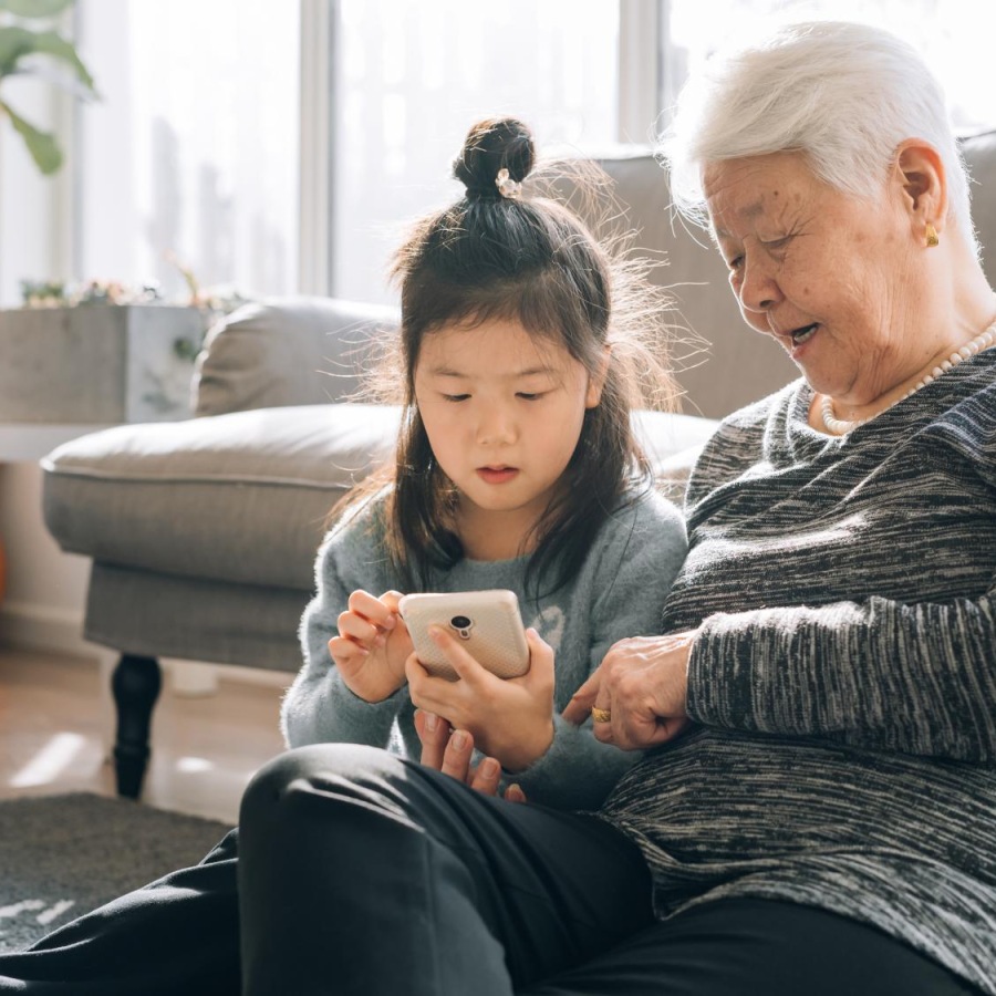 a woman and a child looking at a phone