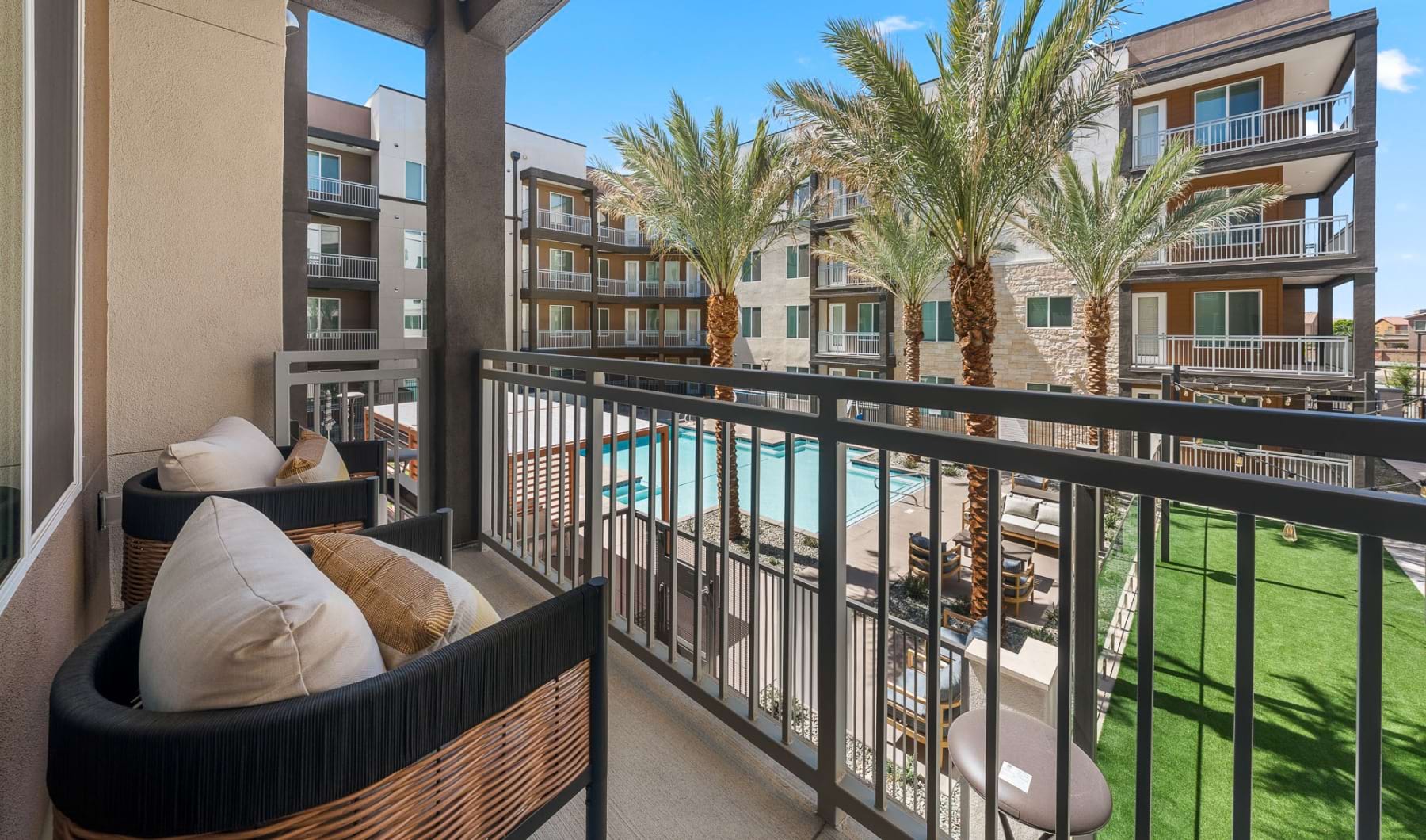 a spacious balcony overlooking a courtyard and a pool
