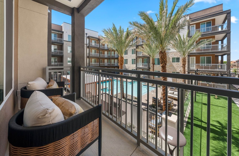a spacious balcony overlooking a courtyard and a pool