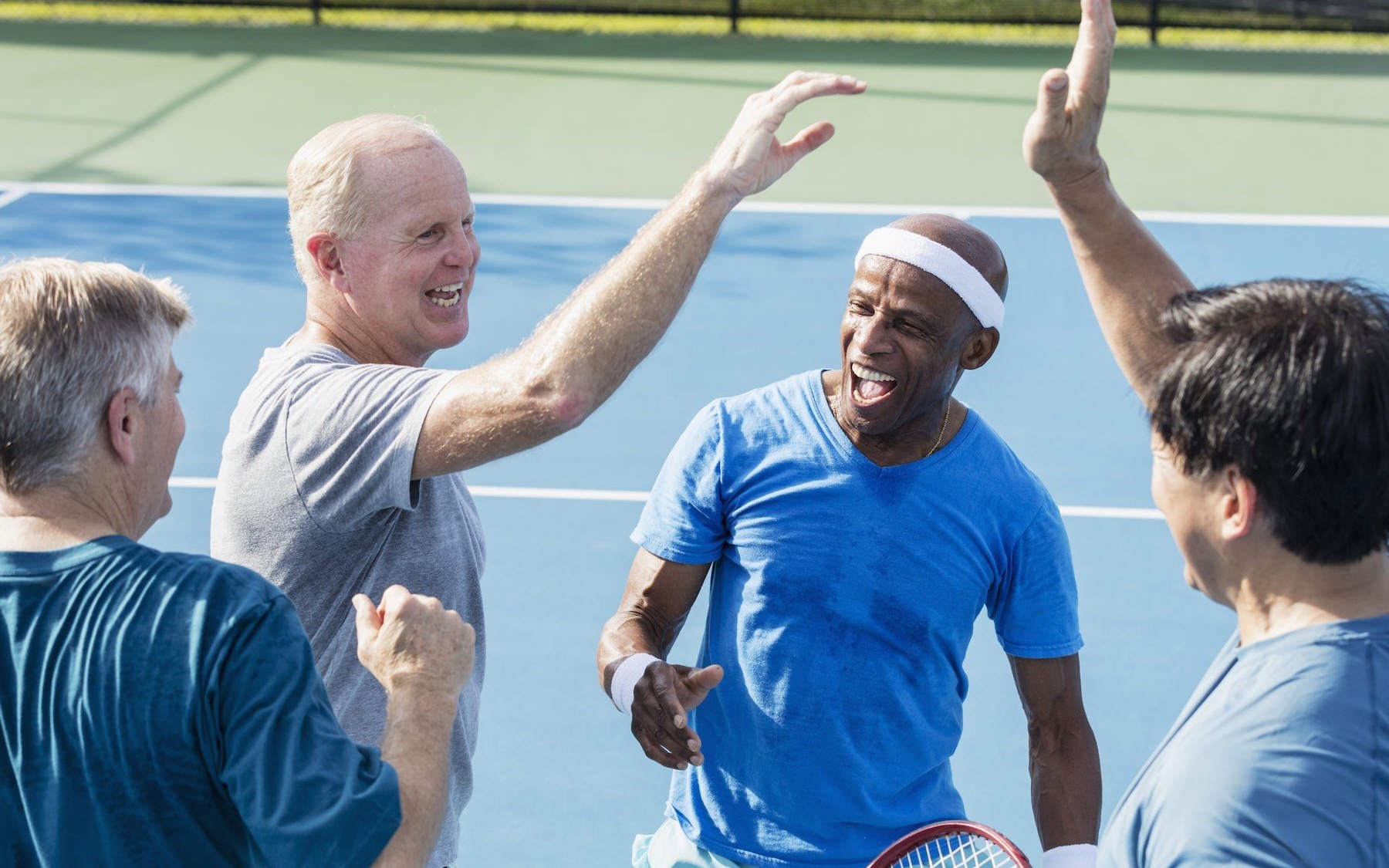 a group of people on a tennis court smiling