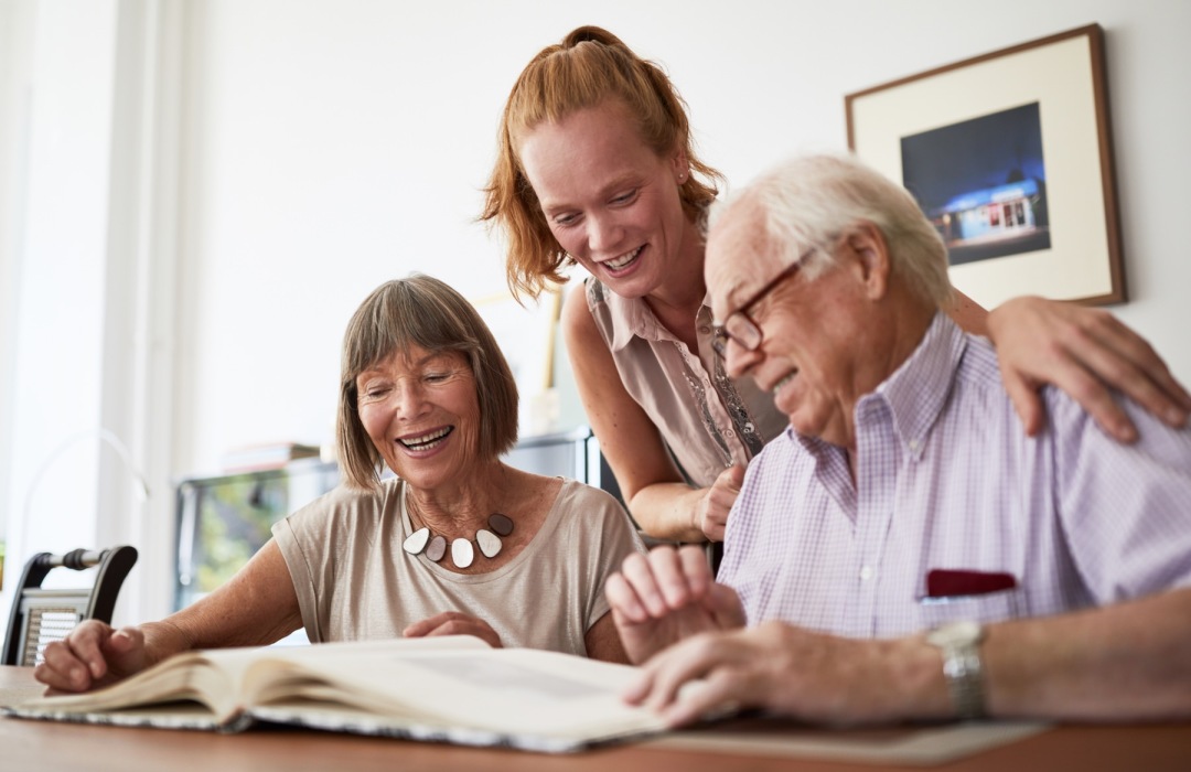 a group of people smiling looking at a book