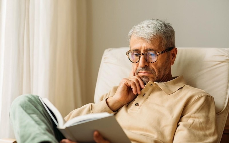 a man sitting on a couch reading