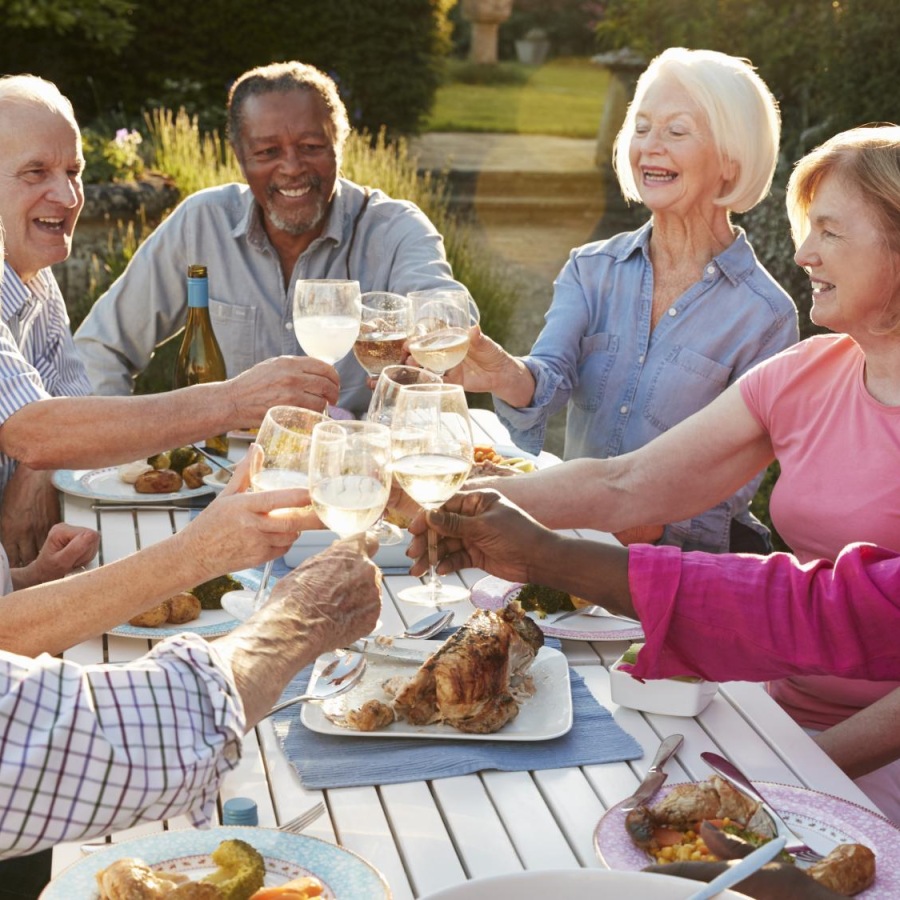 Close to the center of everything a group of people sitting around a table with food and drinks