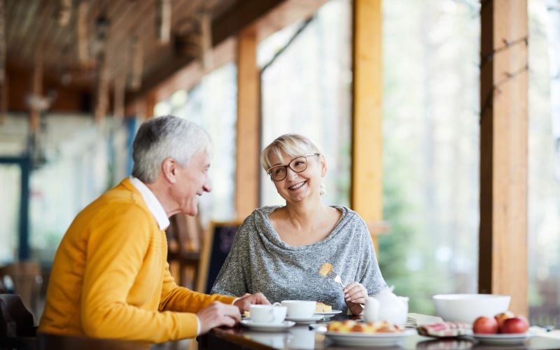 a man and a woman sitting at a table with food