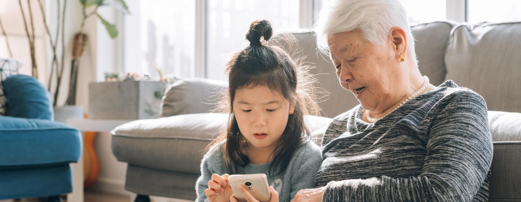 a person and a child looking at a cell phone