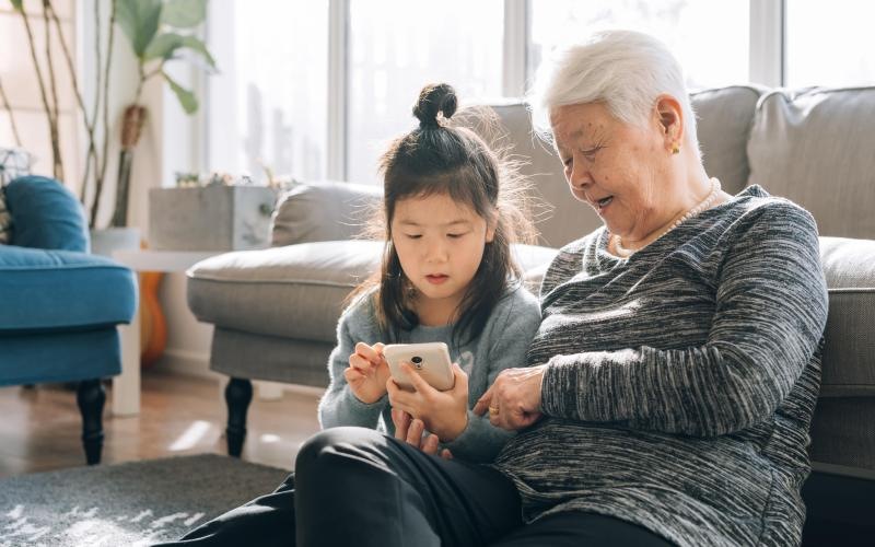 a person and a child looking at a cell phone
