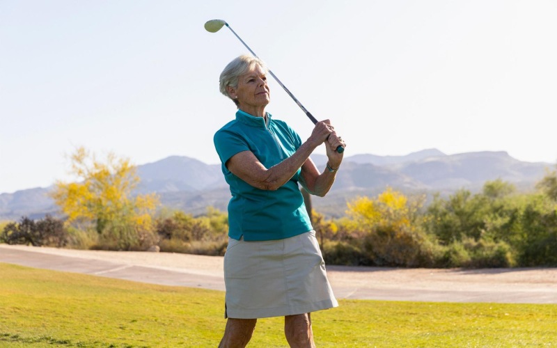 an older woman playing golf