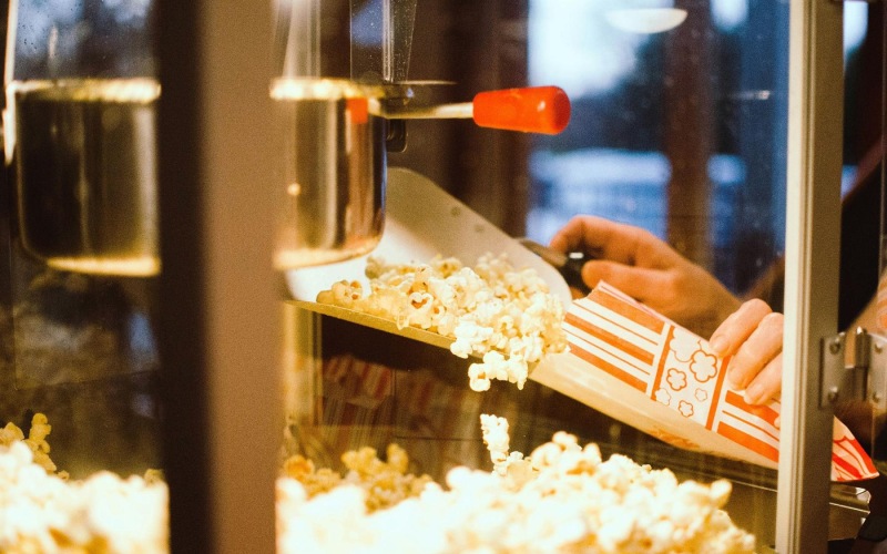 A beautiful community at the heart of all your passions a person pouring popcorn into a container