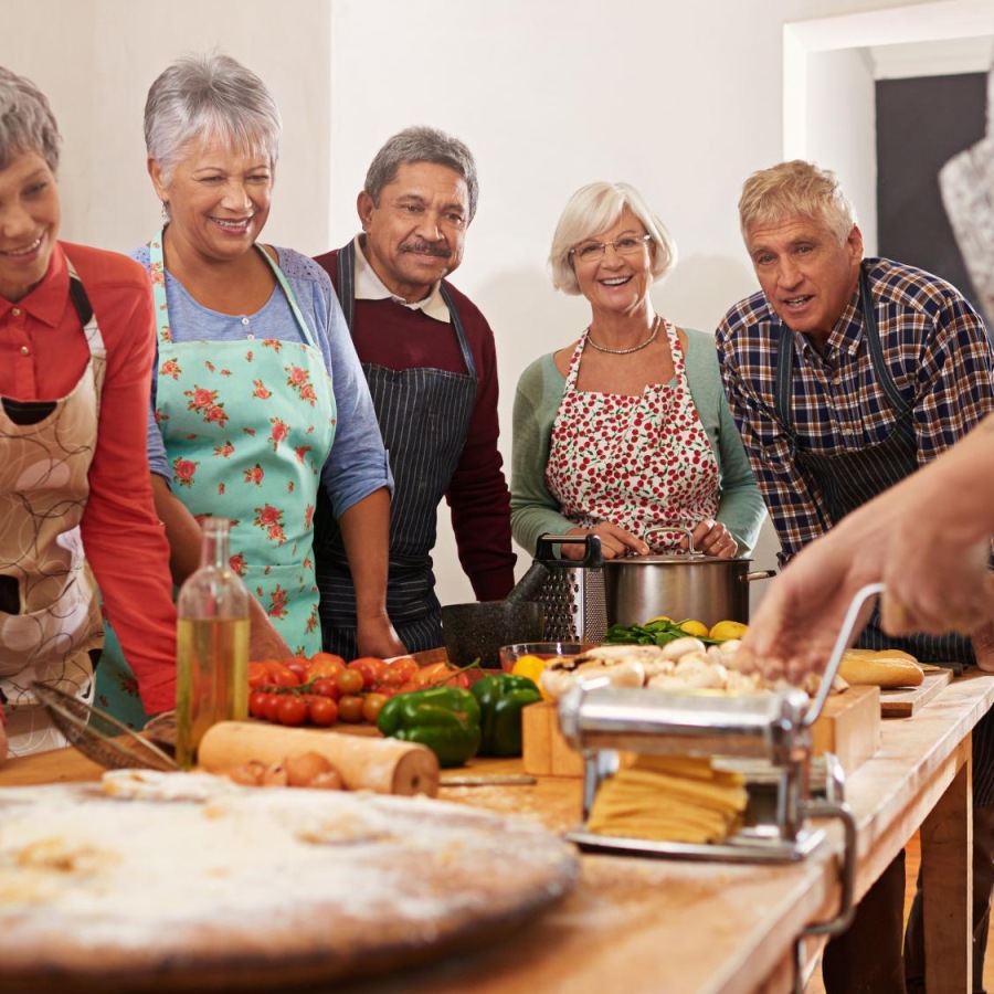 Bustling community with plenty of dining choices A group of people cooking together at Album Quail Springs senior living in Oklahoma City