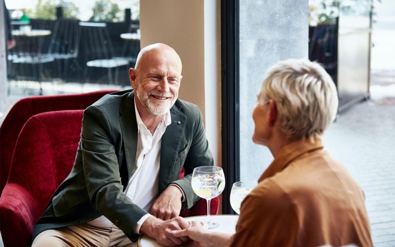 a man and a woman sitting at a table with cocktails