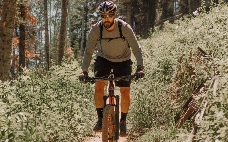 A beautiful community at the heart of all your passions man riding a bike on a trail in the woods