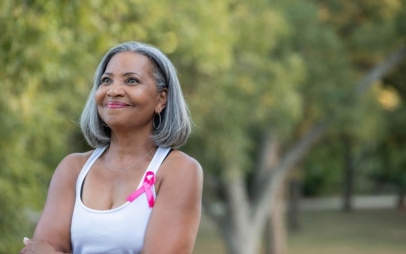 a woman with grey hair smiles to herself in neighborhood park