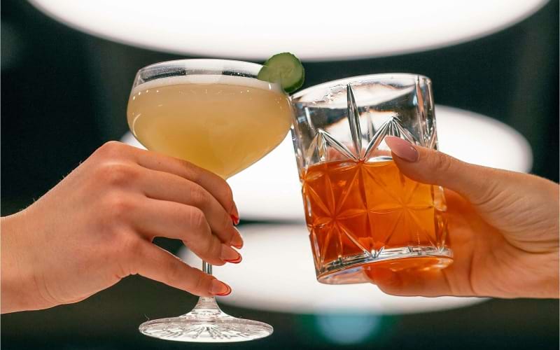 hands holding glasses with cocktails