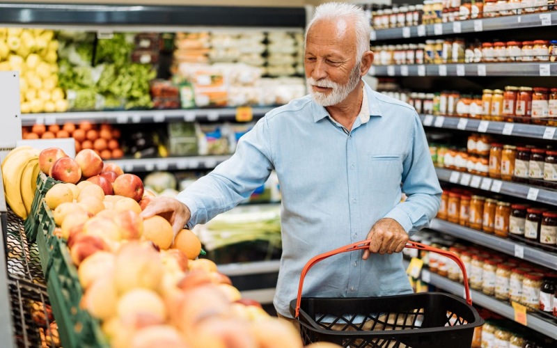a person holding a shopping cart in a grocery store