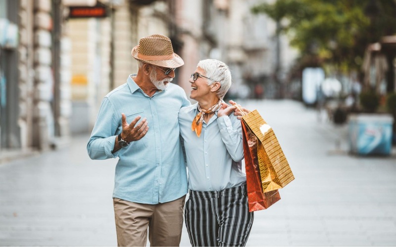 Close to the center of everything a man and woman holding shopping bags while walking