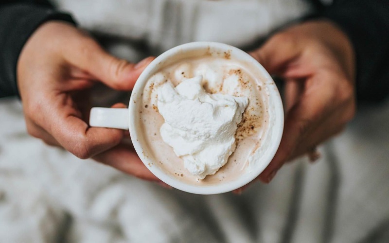 Settle into comfort at Album Marana a person, in bed, holding a cup of coffee