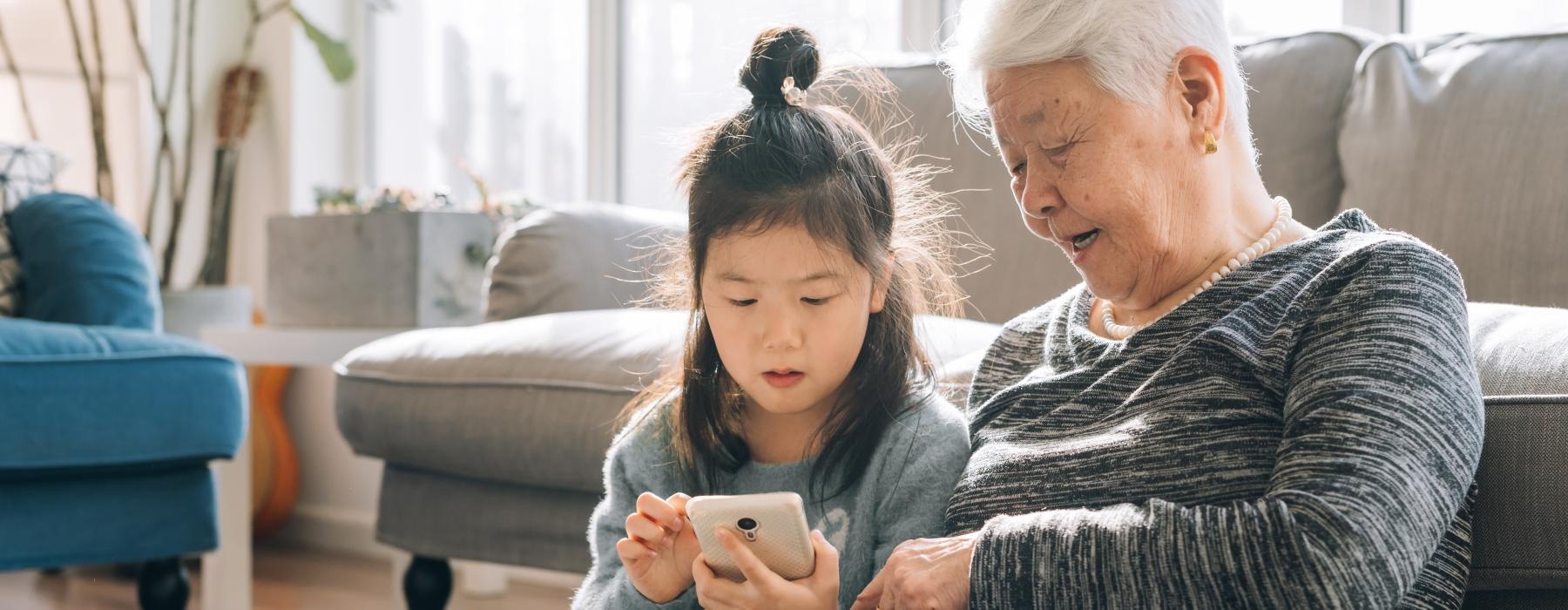 a woman and a child looking at a phone
