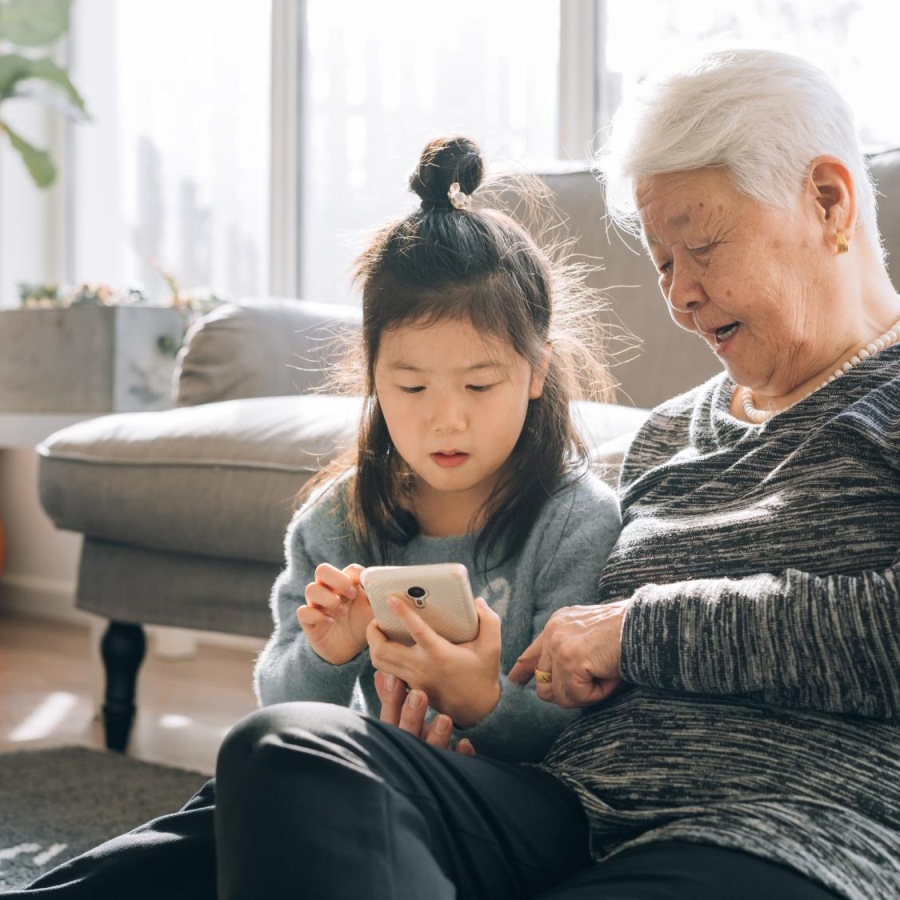 a woman and a child looking at a phone