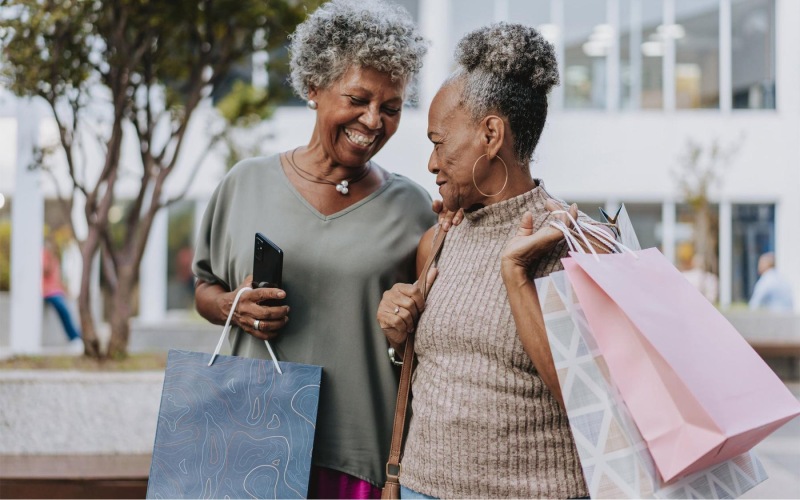 A beautiful community at the heart of all your passions a couple of women smiling and holding shopping bags