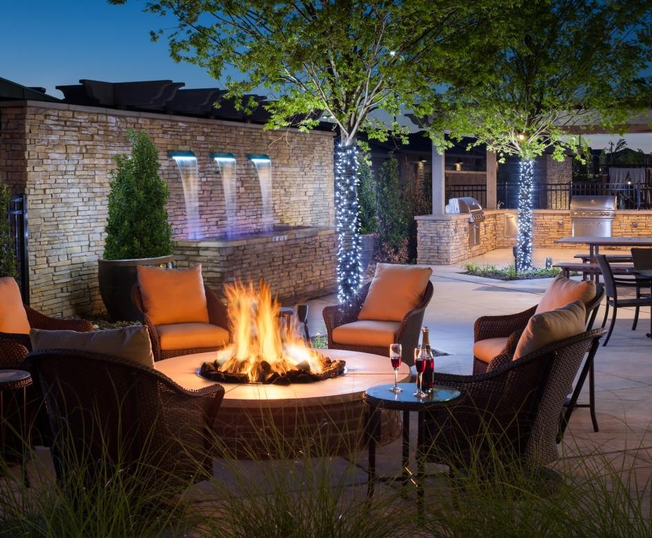 a patio with a fire pit and chairs